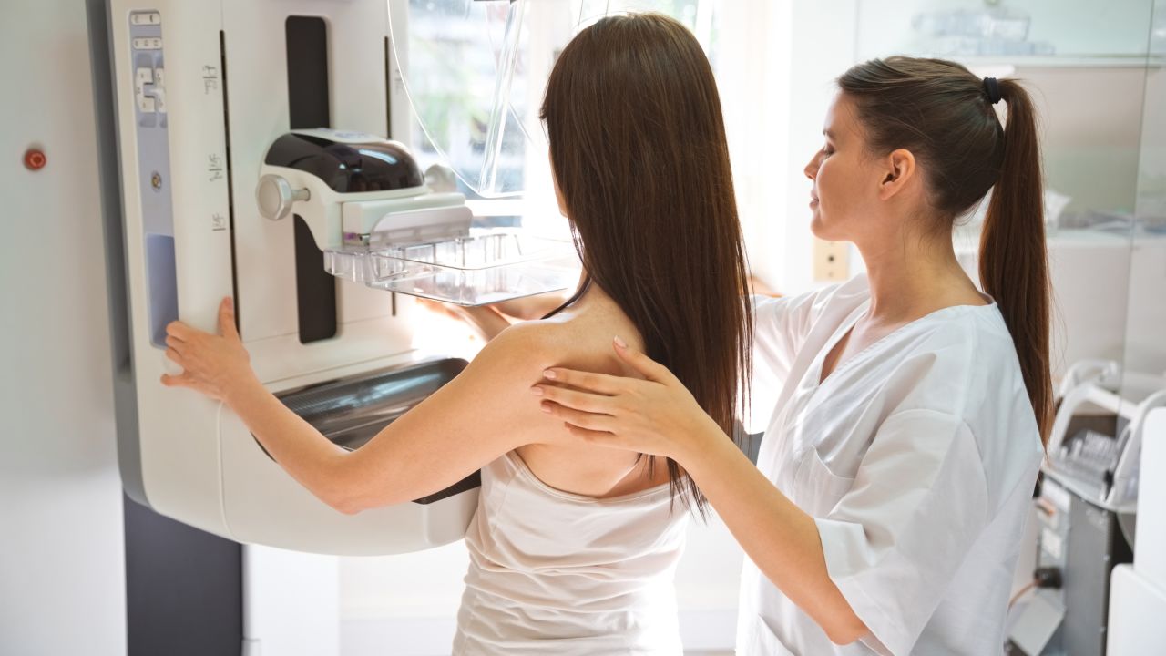 Female doctor and mid adult woman during Mammography test in examination room.