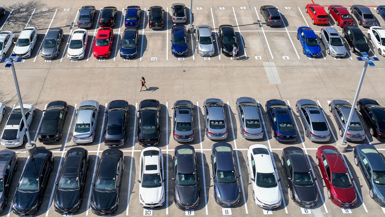 In an aerial view, a customer walks through a Carmax dealership.