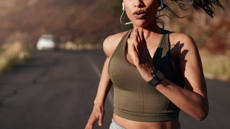 Breathe, music and woman running in the street for fitness, training and marathon in the mountains. Sports, workout and runner in the road with a podcast while doing an outdoor exercise in Germany