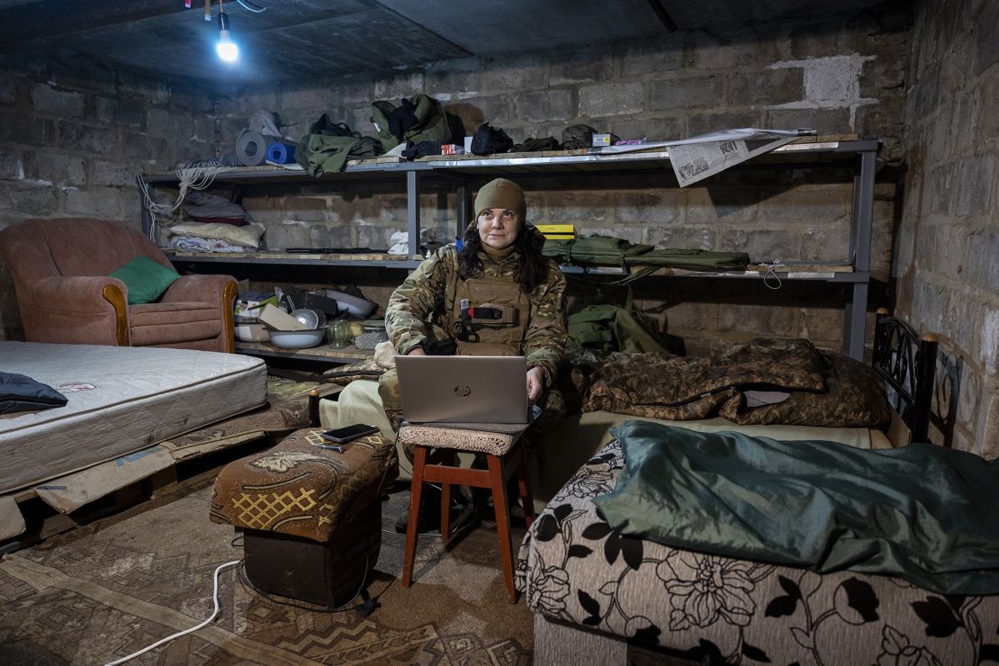 A Ukrainian frontline paramedic uses a Starlink internet connection in a basement living quarters as Russian shells land nearby above ground on February 20, 2023 in the Donbas region of eastern Ukraine.