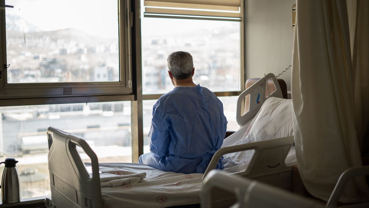 Senior man looking out the window in the hospital room