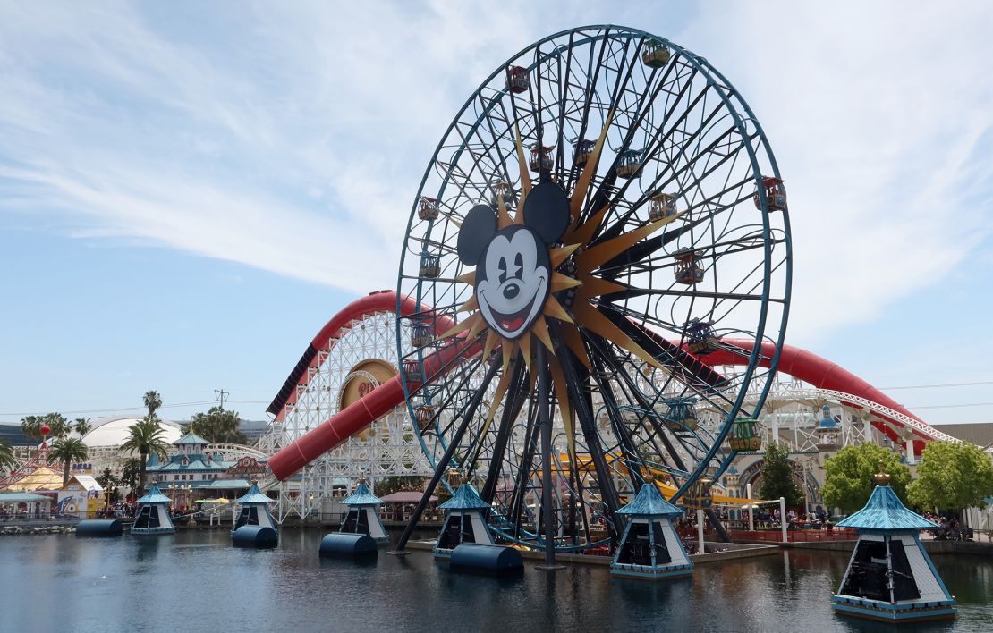 People ride on the Pixar Pal-A-Round ferris wheel in front of the Incredicoaster in the Disney California Adventure Park at Disneyland on April 11, 2023, in Anaheim, California.