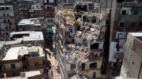 Egyptians gather to inspect the site where a building collapsed in the coastal city of Alexandria on July 15, 2012. Egypt's health ministry said that rescue services had retrieved several bodies from under the rubble of an 11-storey building that collapsed a day earlier in Alexandria. Three neighbouring homes were also destroyed. AFP PHOTO/STR (Photo by AFP) (Photo by STR/AFP via Getty Images)