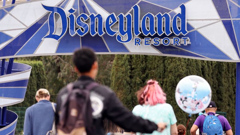 People walk toward an entrance to Disneyland in Anaheim, California on April 24, 2023.