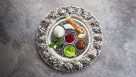 Passover Seder plate with traditional food on grunge background.