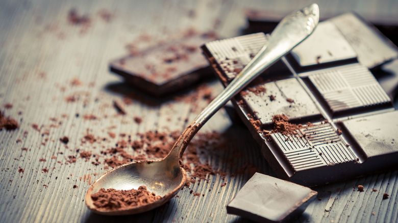Cocoa Powder on spoon and Dark Chocolate background