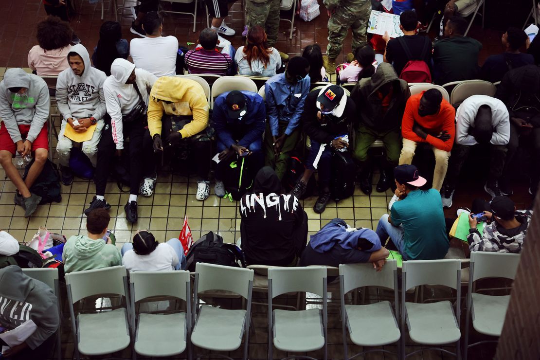 Newly arrived asylum seekers wait in a holding area at the Port Authority bus terminal before being sent off to area shelters and hotels on May 15, 2023, in New York City.