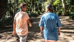 Senior friends talking while walking in the park