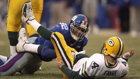 Michael Strahan (left) sacks Brett Favre (right) to break the NFL record.