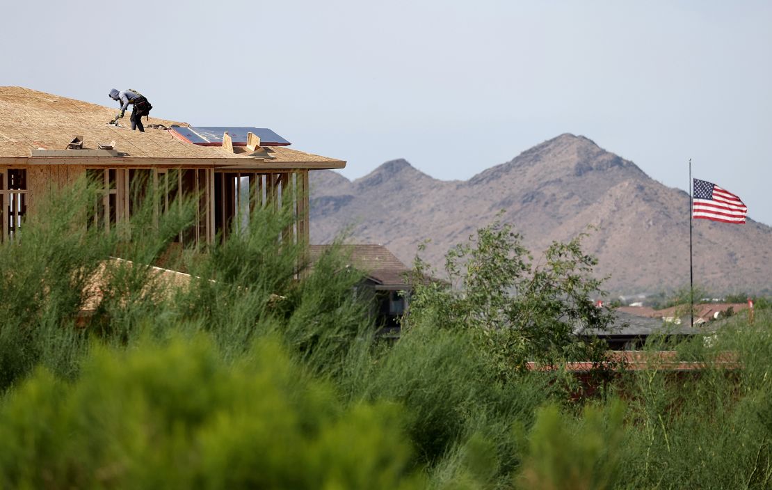 A person works on a rooftop during new home construction at a housing development in the Phoenix suburbs on June 9, 2023 in Queen Creek, Arizona.