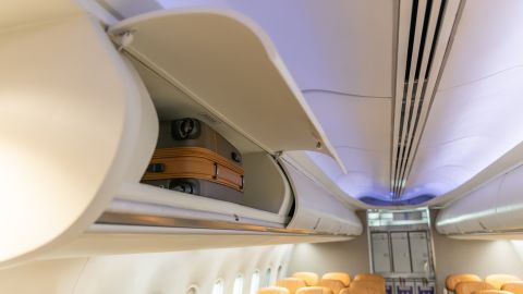 In flight carry on bag cabinet, on board suitcase storage overhead bin in passenger cabin crew.