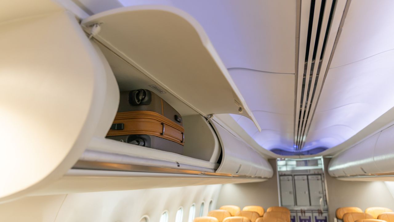 In flight carry on bag cabinet, on board suitcase storage overhead bin in passenger cabin crew.