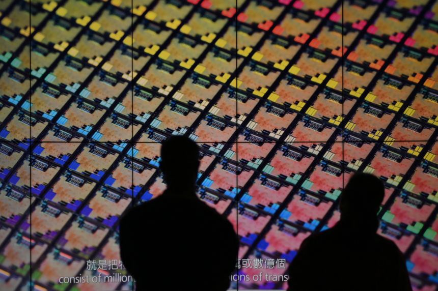 Visitors watch a wafer shown on screens at the Taiwan Semiconductor Manufacturing Company (TSMC) Renovation Museum at the Hsinchu Science Park in Hsinchu, Taiwan, on July 5, 2023.
