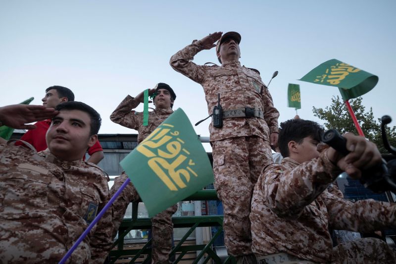 Islamic Revolutionary Guard Corps military personnel salute while a group of schoolboys and schoolgirls (not pictured) chanting Hymn Hello Commander, in the Azadi (Freedom) avenue during a rally commemorating Eid al-Ghadir in Tehran, July 7, 2023.