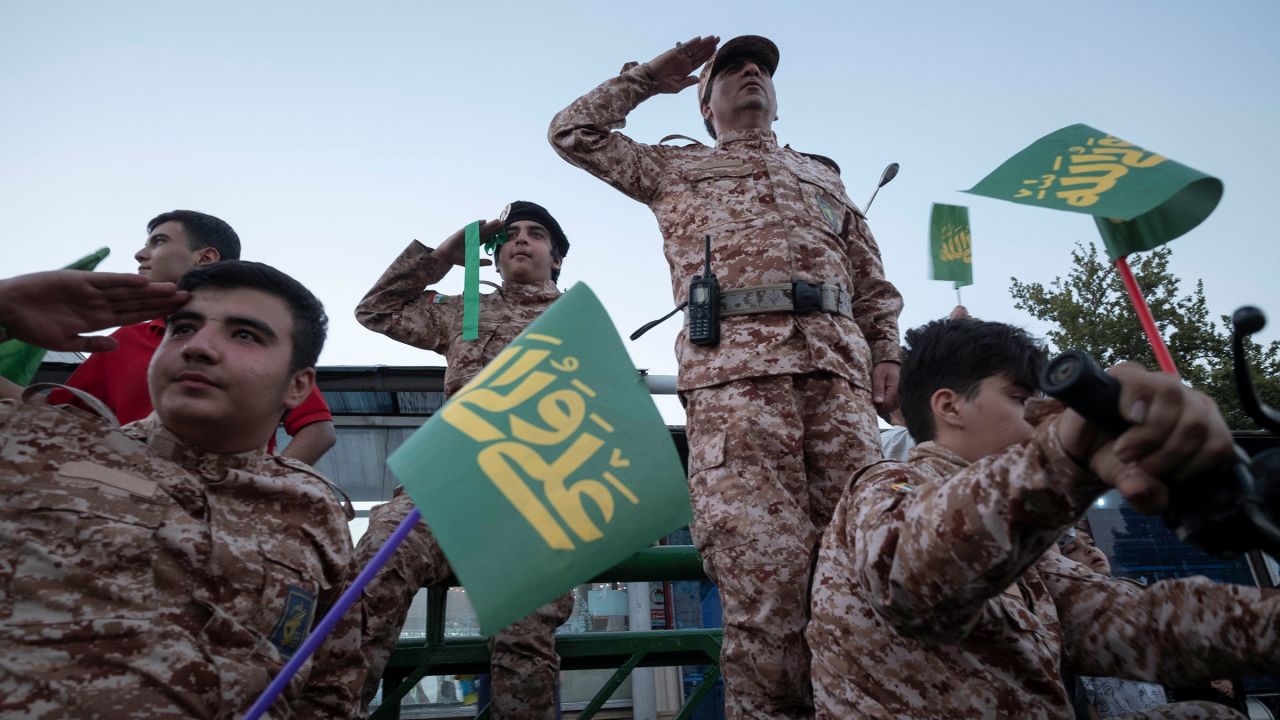 Islamic Revolutionary Guard Corps military personnel salute while a group of schoolboys and schoolgirls (not pictured) chanting Hymn Hello Commander, in the Azadi (Freedom) avenue during a rally commemorating Eid al-Ghadir in Tehran, July 7, 2023.