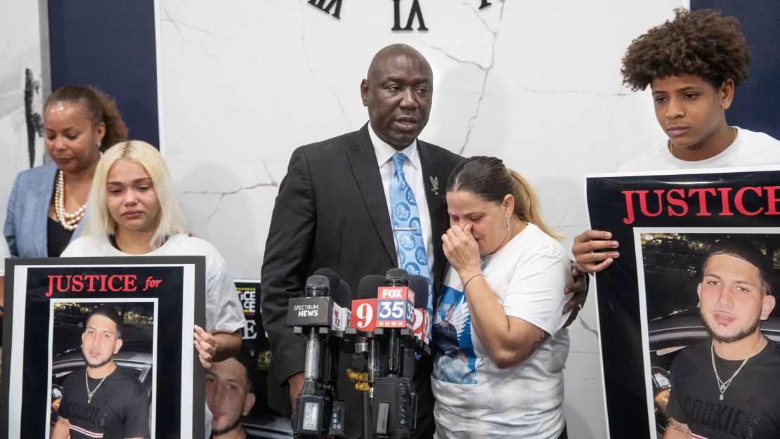 Attorney Ben Crump holds Yaneri Diaz Rodriguez as she cries during a news conference about the killing of her son, Derek Diaz.