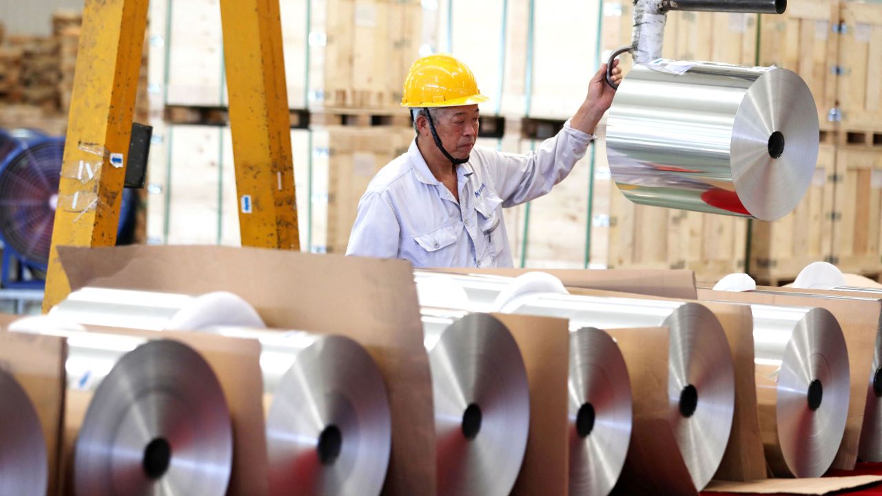 This photo taken on July 8, 2023 shows a worker positioning rolls of battery aluminium foil, produced for export, at a factory in Huaibei, in China's eastern Anhui Province. (Photo by AFP) / China OUT (Photo by STR/AFP via Getty Images)