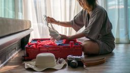 Woman packing suitcase for summer  travel trip.