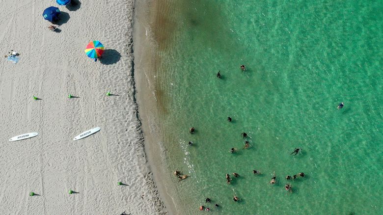 MIAMI, FLORIDA - JULY 11:  In an aerial view,  people enjoy the Atlantic Ocean's waters along the beach at Haulover Park on July 11, 2023 in Miami, Florida. The surface ocean temperatures in parts of Florida are 92 to 96 degrees Fahrenheit, the warmer coastal ocean water is threatening Florida's coral reefs, and could create stronger tropical storms and hurricanes. (Photo by Joe Raedle/Getty Images)