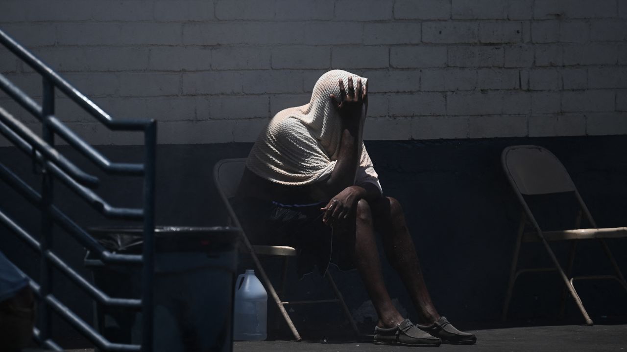 TOPSHOT - A person covers their head while trying to stay cool in "The Zone," a vast homeless encampment where hundreds of people reside, during a record heat wave in Phoenix, Arizona on July 18, 2023. Swaths of the United States home to more than 80 million people were under heat warnings or advisories, as relentless, record-breaking temperatures continued to bake western and southern states. In Arizona, state capital Phoenix recorded its 17th straight day above 109 degrees Fahrenheit (43 degrees Celsius), as temperatures hit 113F (45C) Sunday afternoon. (Photo by Patrick T. Fallon / AFP) (Photo by PATRICK T. FALLON/AFP via Getty Images)