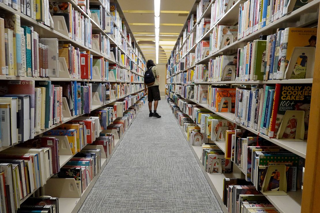 Una persona mira libros en una biblioteca pública de Miami-Dade el 19 de julio de 2023 en Miami, Florida.