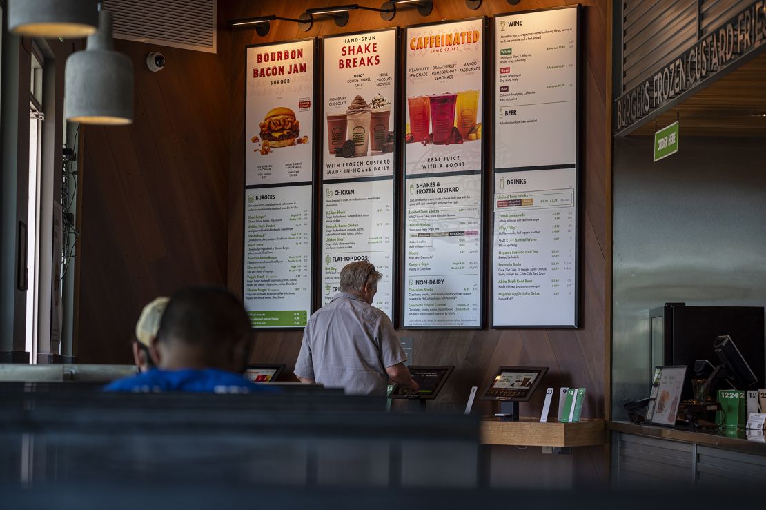 A customer orders food at a kiosk in a Shake Shack restaurant in Larkspur, California, on Thursday, July 20, 2023.