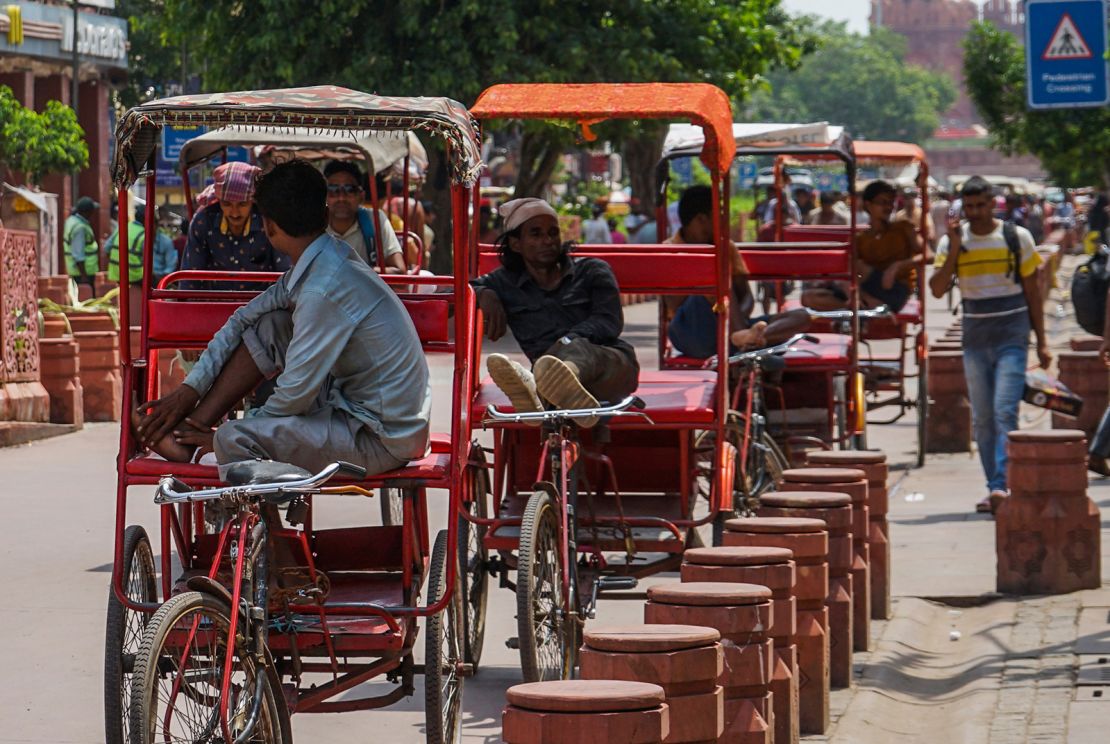 Rickshaw pullers rest along a street in Chandni Chowk, Old Delhi, India on August 6, 2023.