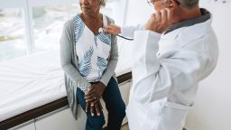 Portrait of a doctor listening to an elderly woman patient's heartbeat