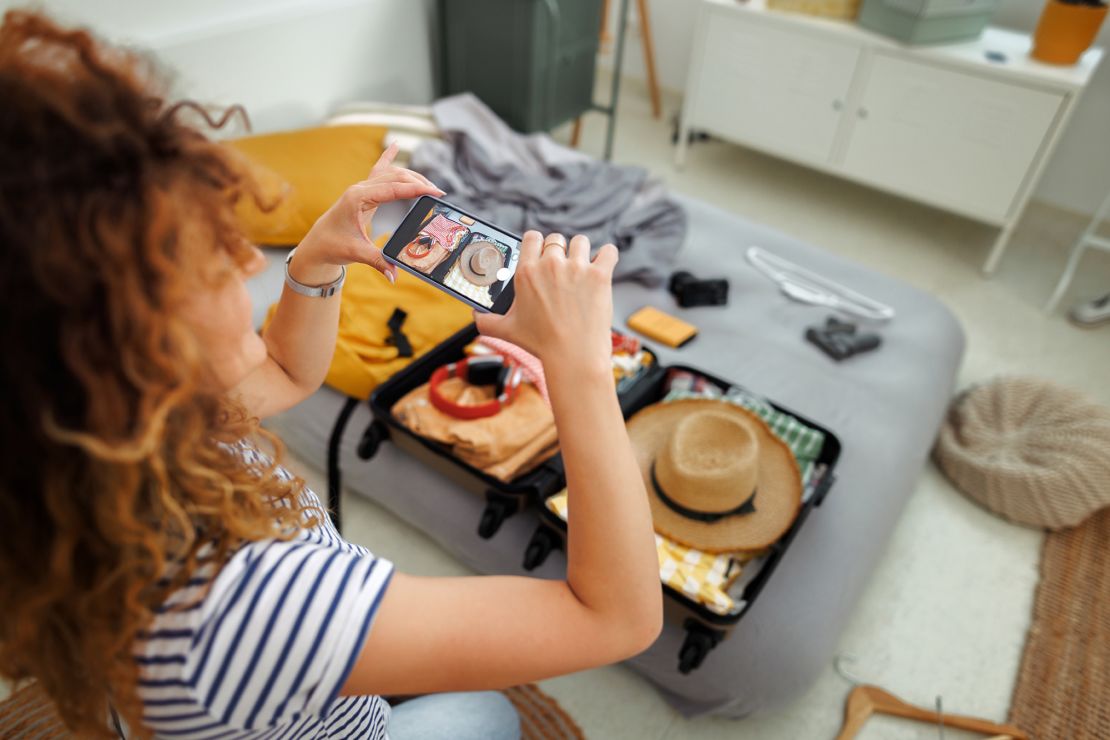 This traveler snaps a photo of her packed suitcase at home. That could come in handy later if the luggage is lost or stolen.