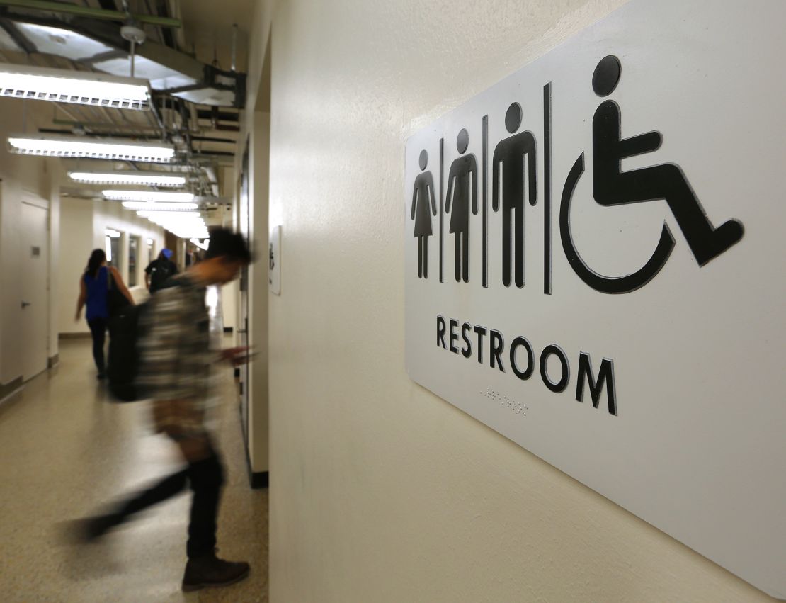 Students pass by a sign for a unisex bathroom next to the men's and women's restroomS at the University of Houston Downtown, Thursday, Nov. 5, 2015.