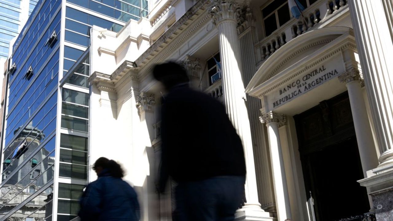 People walk past Argentina's Central Bank in Buenos Aires on August 14, 2023, a day after the primary elections. Argentine monetary authorities on Monday devalued the peso by around 20 percent in anticipation of a market backlash to the strong performance of far-right politician Javier Milei in a presidential primary election. The Banco Nacion state bank showed the peso trading at 365.50 to the dollar, up from 298.50 on Friday. (Photo by JUAN MABROMATA / AFP) (Photo by JUAN MABROMATA/AFP via Getty Images)