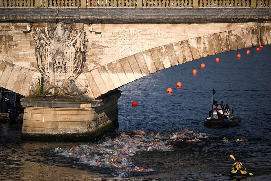 Triathlon athletes swim in the Seine river during the men's 2023 World Triathlon Olympic Games Test Event in Paris, on August 18, 2023. From August 17 to 20, 2023, Paris 2024 is organising four triathlon events to test several arrangements, such as the sports operations, one year before the Paris 2024 Olympic and Paralympic Games. The swim familiarisation event follows the cancellation on August 6 of the pre-Olympics test swimming competition due to excessive pollution which forced organisers to cancel the pre-Olympics event. (Photo by Emmanuel DUNAND / AFP) (Photo by EMMANUEL DUNAND/AFP via Getty Images)