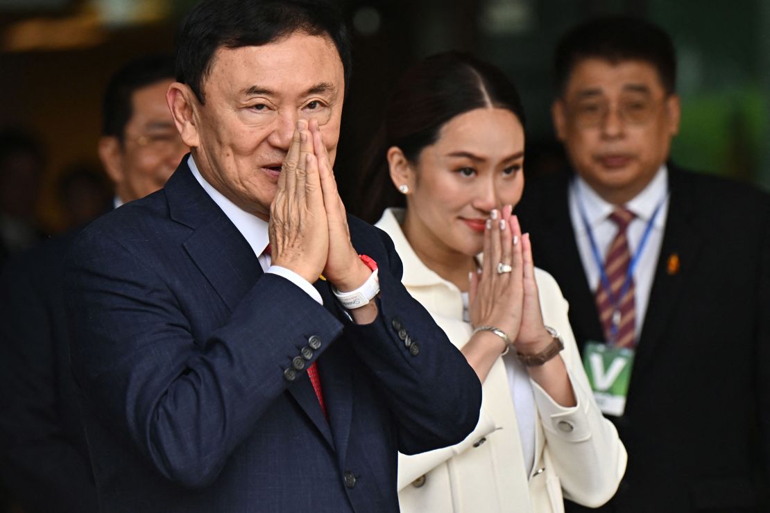 Former Thai Prime Minister Thaksin Shinawatra greets his supporters, alongside his youngest daughter Paetongtarn Shinawatra, at Bangkok's Don Mueang airport on August 22, 2023.