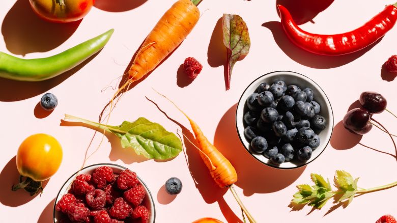 Pattern of variety fresh of organic berry fruits and vegetables and healthy vegan meal ingredients on pink background. Concept of food, vegetable, agriculture, harvest, food producer and healthy and vegetarian food.. Flat lay, top view