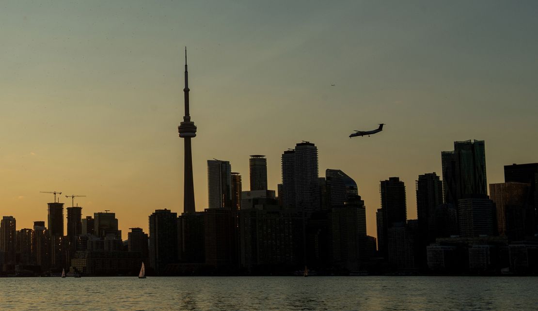 A plane flies over the Canadian National tower and the Toronto skyline on September 14, 2023.