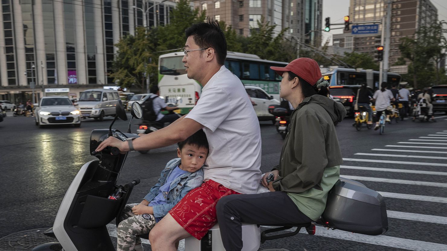 A boy riding with his parents on a scooter in Beijing, China, on September 13, 2023.