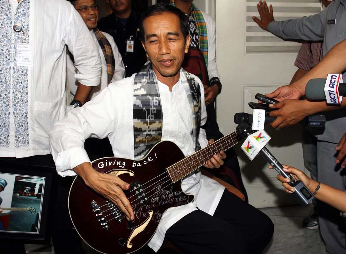 This picture taken in 2013 shows then-Jakarta governor Jokowi holding an autographed maroon bass guitar gifted to him by Metallica's Robert Trujillo.