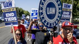Striking United Auto Workers (UAW) march in front of the Stellantis Mopar facility on September 26, 2023 in Ontario, California.