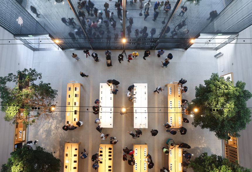 People are reflected in an overhead mirror as they gather to purchase new Apple iPhone 15 models in on September 22, 2023 in Los Angeles, California.