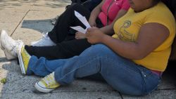 TO GO WITH AFP STORY BY YEMELI ORTEGA LUYANDO - A woman with obesity sits on the sidewalk in Mexico City on May 20, 2013. Obesity among Mexicans soared from 9.5% in 1988 to 32% in 2012 and if overweight is included, up to 70%. The Mexicans also contribute with 22,000 out of the 180,000 people who die annually in the world from conditions related to the intake of sweet drinks, a figure that doubles the 10,000 deaths caused by the organized crime in the country.  AFP PHOTO (Photo by AFP) (Photo by STR/AFP via Getty Images)