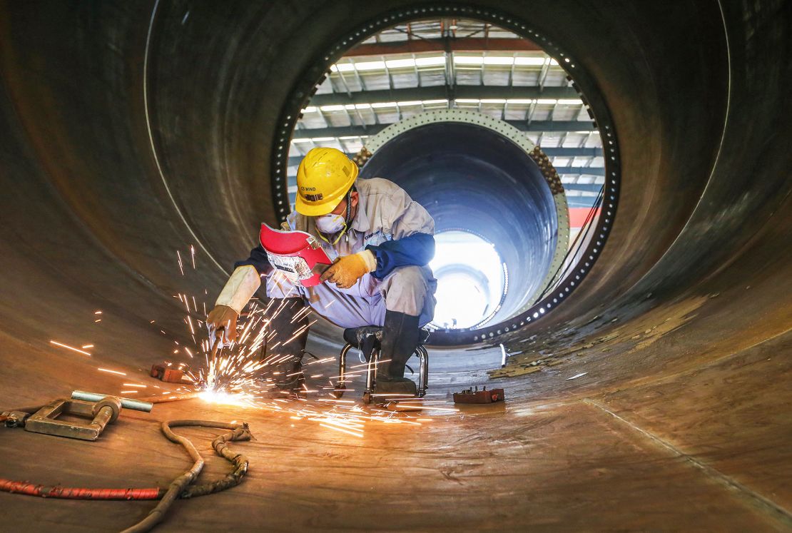 An employee works on a wind turbine tower at a factory in Lianyungang, China, in October 2023.