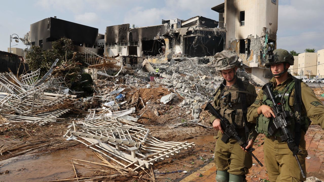 TOPSHOT - Soldiers walk in front of an Israeli police station that was damaged during battles to dislodge Hamas militants who were stationed inside, on October 8, 2023. Israel's prime minister of October 8 warned of a "long and difficult" war, as fighting with Hamas left hundreds killed on both sides after a surprise attack on Israel by the Palestinian militant group. (Photo by JACK GUEZ / AFP) (Photo by JACK GUEZ/AFP via Getty Images)