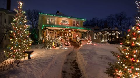 Snow blankets a historic home decked out for the holiday season.