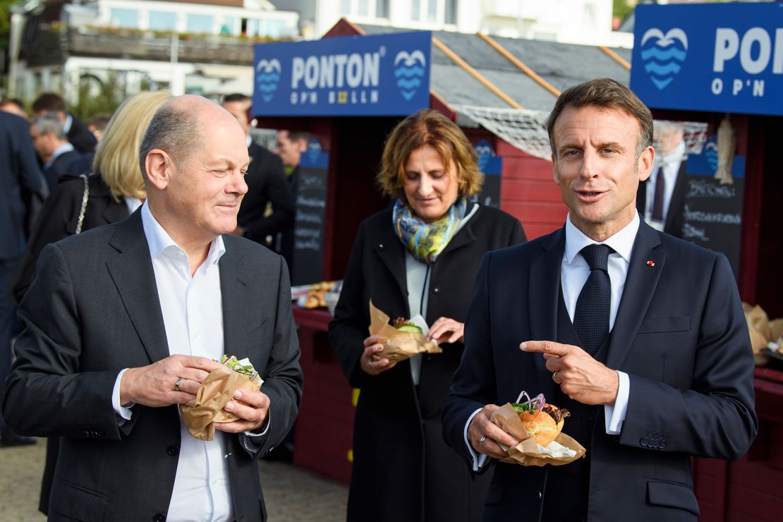 German Chancellor Olaf Scholz, left, and French President Emmanuel Macron, right, eat fish sandwiches during a German-French government retreat, on October 10, 2023 in Hamburg, Germany.