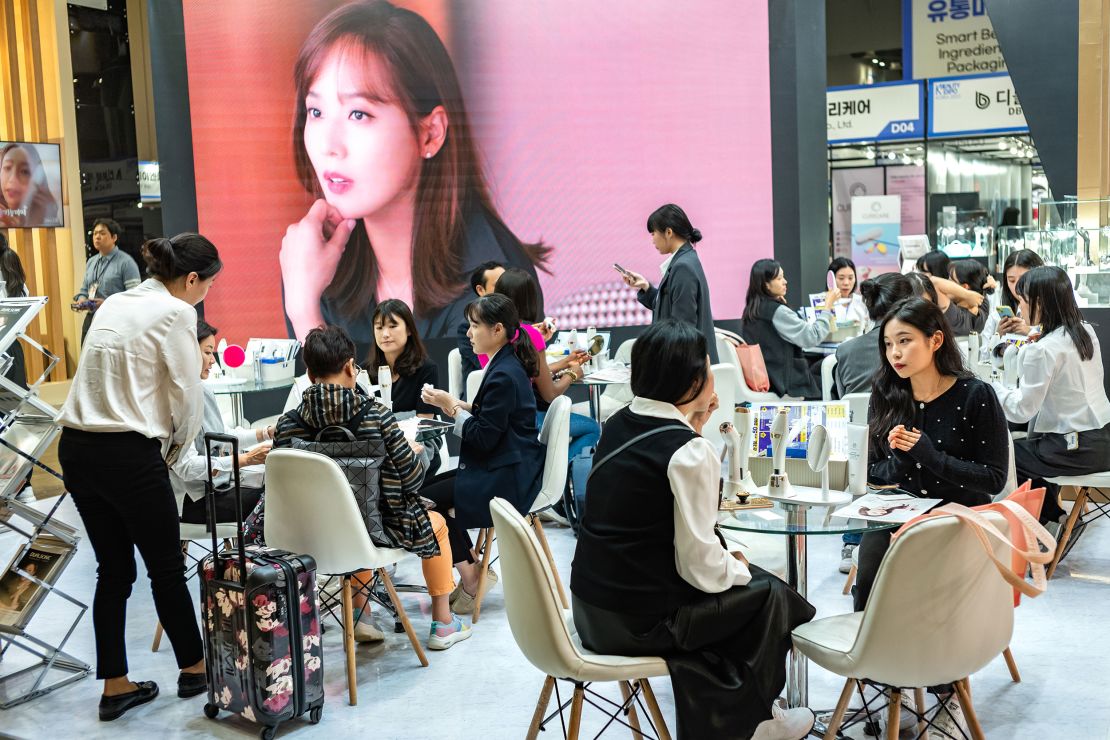 Visitors and vendors discuss beauty products at the K-Beauty Expo, the largest beauty exhibition in South Korea, on October 12, 2023 in Goyang, South Korea.