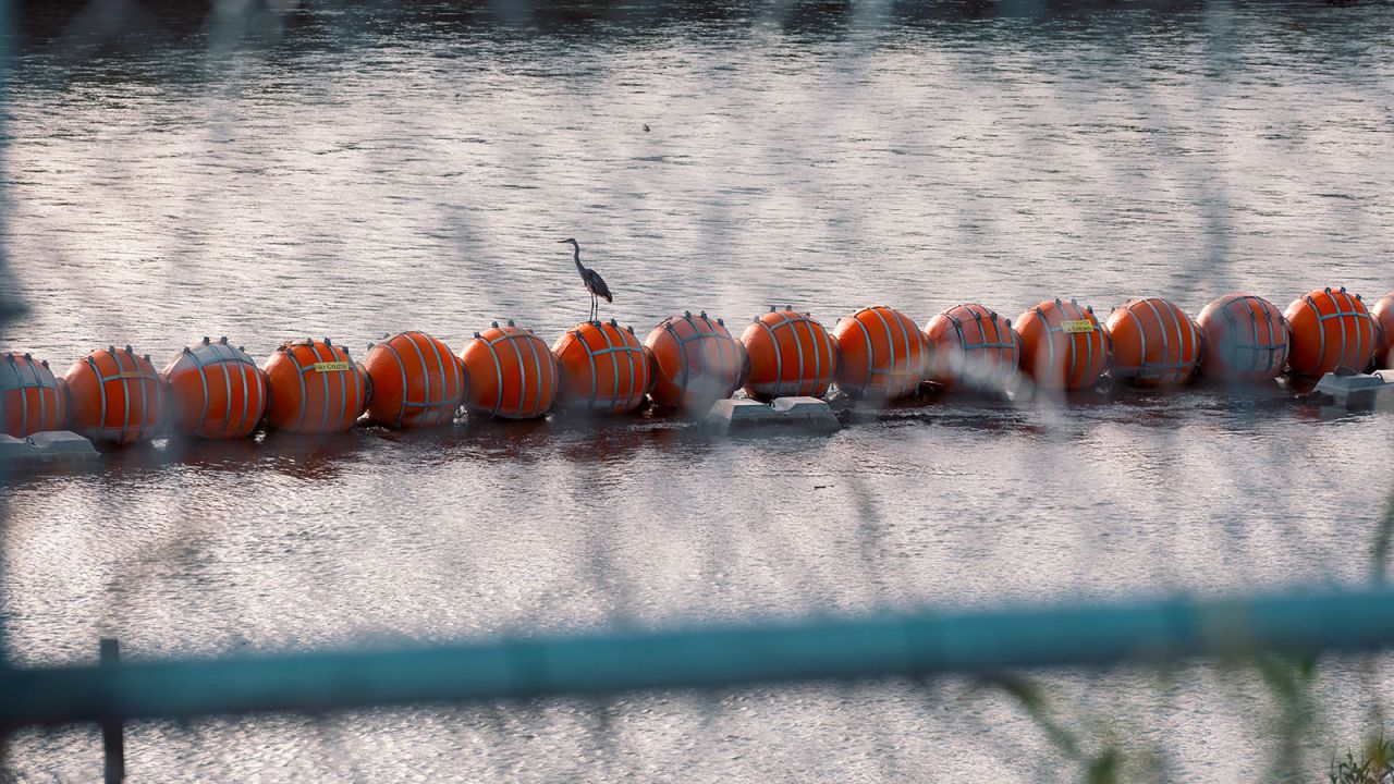 Buoys meant to deter migrant crossings in the Rio Grande River in Eagle Pass, Texas, US, on Wednesday, Oct. 11, 2023. President Biden said he sought to redirect funds to build a border wall but was unsuccessful as his administration announced plans last week to add roughly 17 miles of barriers along the Rio Grande in Texas. Photographer: Jordan Vonderhaar/Bloomberg via Getty Images