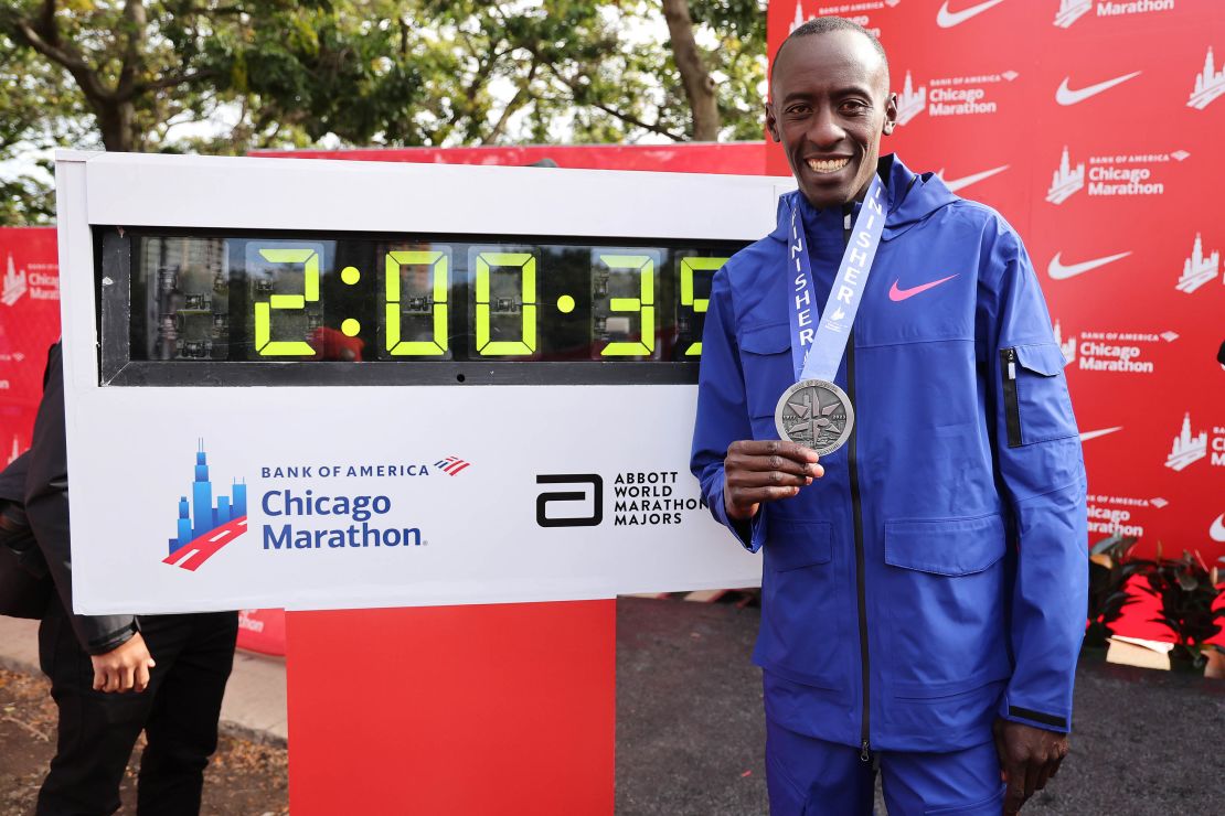 Kiptum stands next to a timer displaying his marathon world record in Chicago.