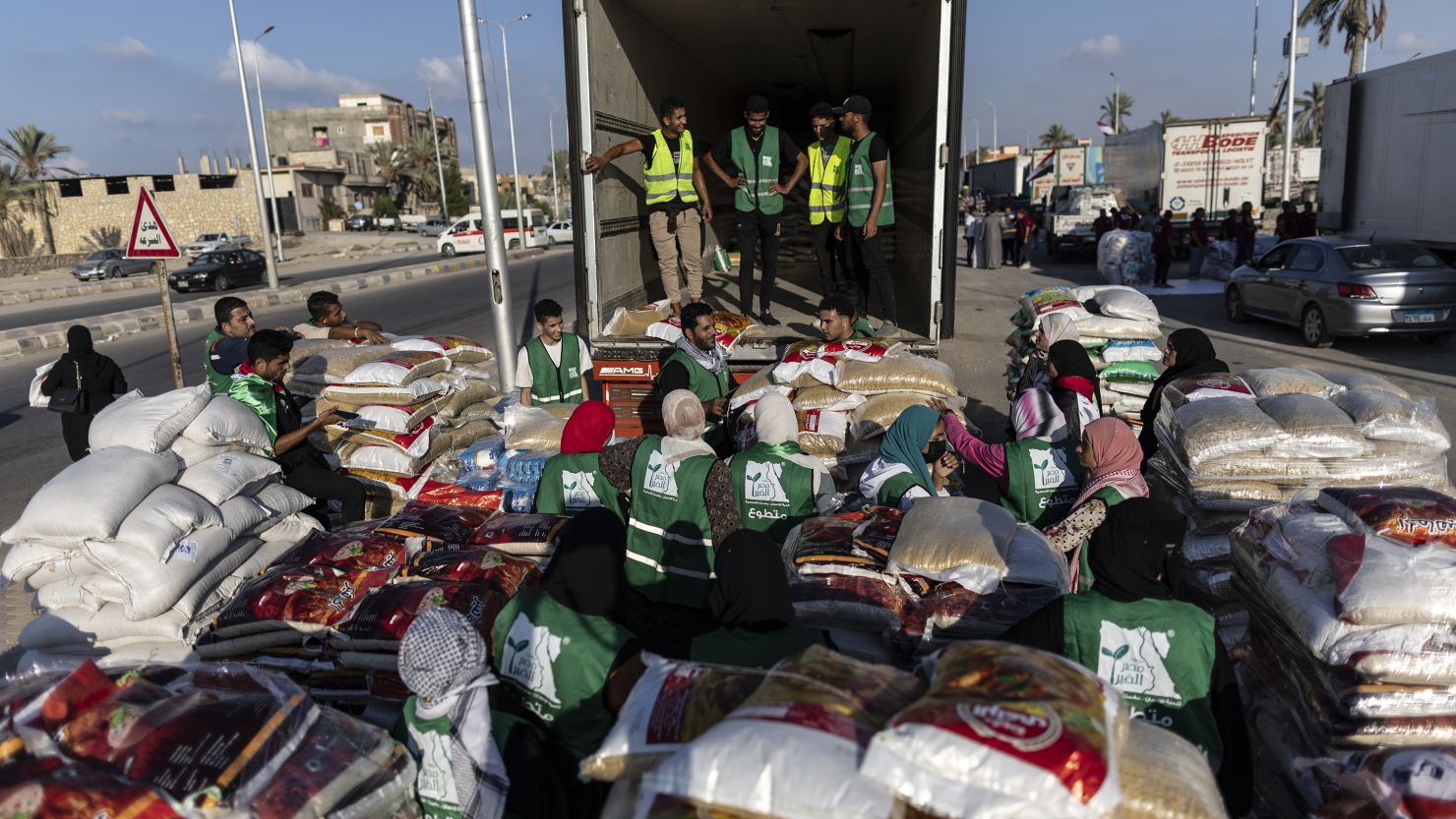 Volunteers load food and supplies onto trucks in an aid convoy for Gaza on October 16, in North Sinai, Egypt.
