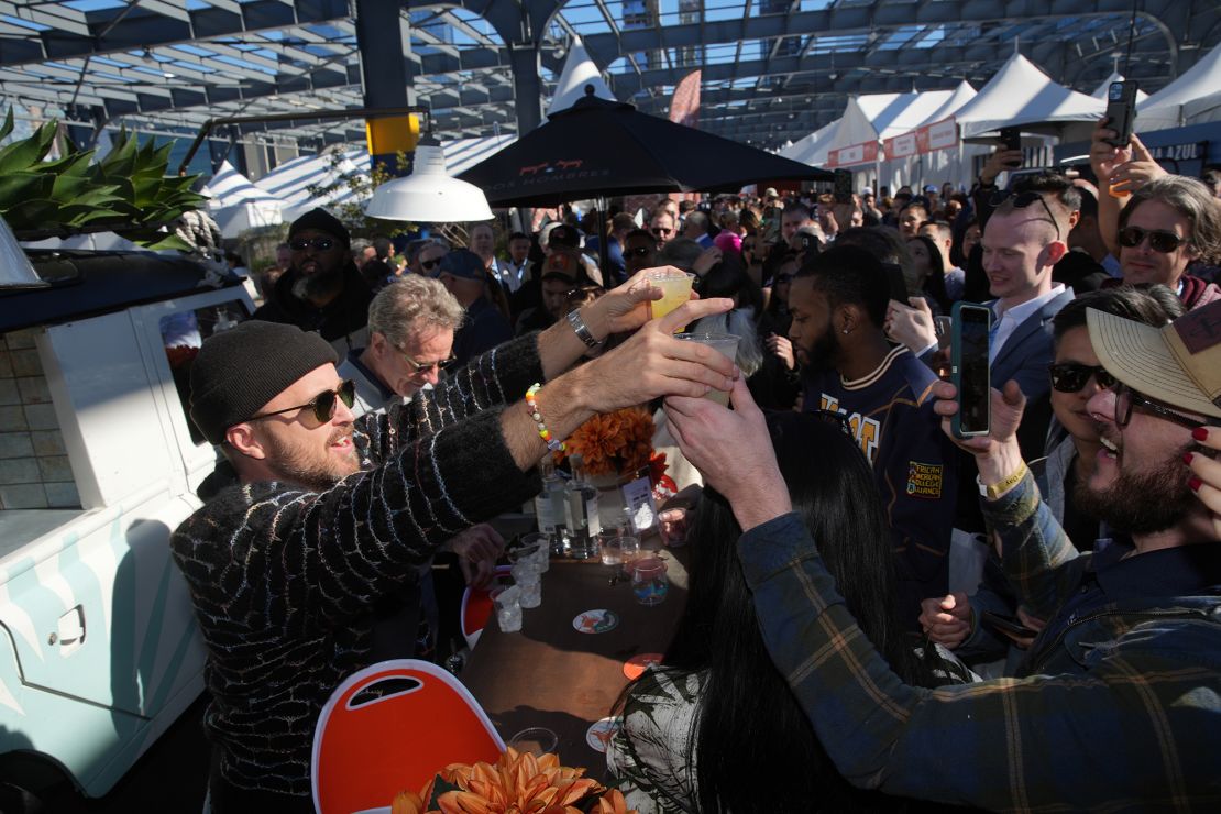 Aaron Paul and Bryan Cranston serve Dos Hombres Mezcal at the Food Network New York City Wine and Food Festival in 2023.