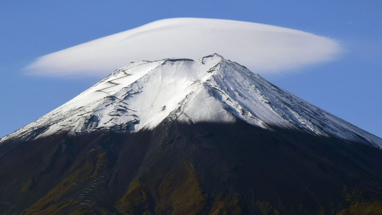 Photo taken Oct. 20, 2023, from Fujiyoshida in Japan's Yamanashi Prefecture shows a cap cloud over the top of Mt. Fuji. (Photo by Kyodo News via Getty Images)